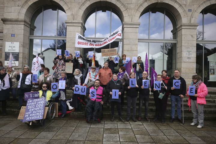 [반=AP/뉴시스] 24일 프랑스 브르타뉴 반 법원 앞에서 299명의 아동 환자를 성폭행한 혐의를 받고 있는 프랑스 외과 의사 조엘 르 스콰르넥의 재판 첫날 시위대들이 현수막을 들고 시위를 벌이고 있다. 2025.02.26. *재판매 및 DB 금지