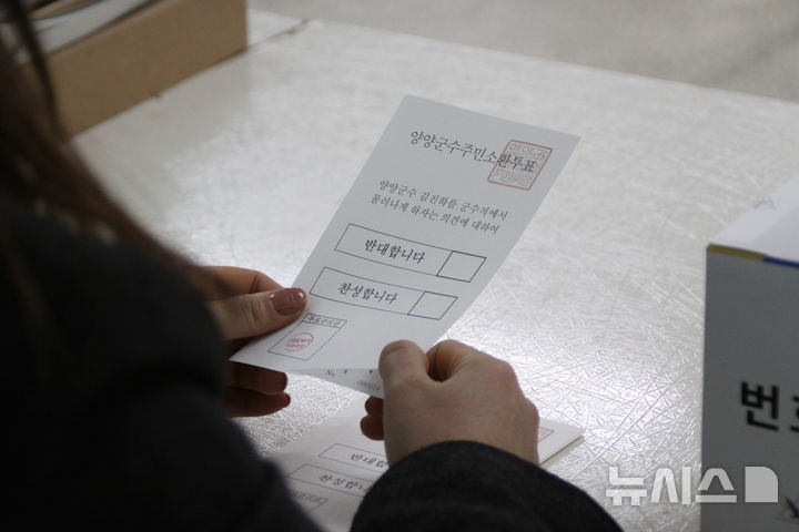 [양양=뉴시스] 이순철 기자 = 김진하 양양군수의 주민소환투표 본투표일인 26일 강원 양양군 일출예식장에 마련된 양양읍 제1투표소에서 투표사무원이 주민에게 투표용지를 전달하고 있다. 2025.02.26. grsoon815@newsis.com