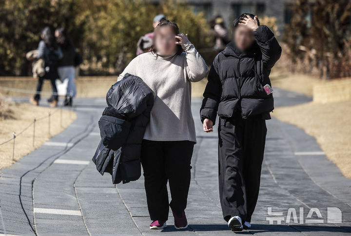 [서울=뉴시스] 정병혁 기자 = 포근한 날씨를 보인 26일 서울 종로구 열린송현공원에서 한 시민이 겉옷을 들고 이동하고 있다. 2025.02.26. jhope@newsis.com