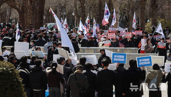 [인천=뉴시스] 전진환 기자 = 26일 오후 인천 인천 미추홀구 인하대학교에서 윤석열 대통령 탄핵 반대 측과 탄핵 찬성 측 지지자들이 피켓을 들고 마주하고 있다. 2025.02.26. amin2@newsis.com
