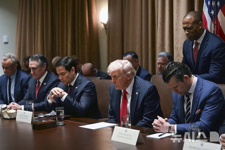 [워싱턴=AP/뉴시스] 도널드 트럼프 미국 대통령이 26일(현지 시간) 미 워싱턴 백악관에서 열린 트럼프 행정부 첫 국무회의에서 기도하고 있다. 2025.02.27.