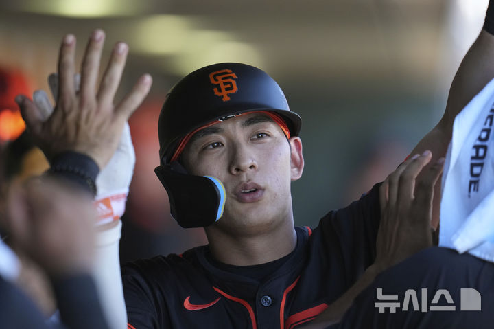 [스코츠데일=AP/뉴시스] 샌프란시스코 자이언츠의 이정후가 26일(현지 시간) 미 애리조나주 스코츠데일 스타디움에서 열린 2025 MLB 시범경기 시카고 컵스와 경기 3회 말 상대 투수 폭투로 득점한 후 동료들의 환영을 받고 있다. 이정후는 2타수 무안타 1사사구 1득점을 기록했고 팀은 4-4 무승부를 기록했다. 2025.02.27.