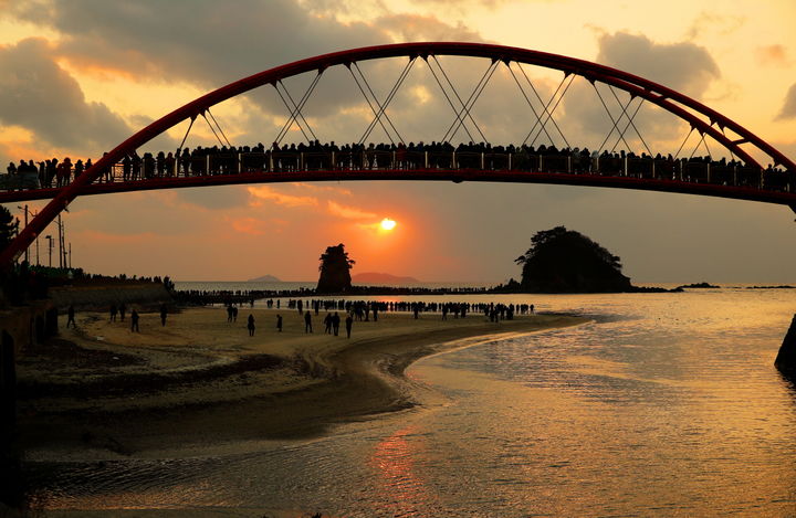 [태안=뉴시스] 태안군 안면읍 꽃지해수욕장 방포항 꽃다리 뒤로 할미 할아비 바위 사이 저녁 노을이 하늘을 물들고 있다. (사진=태안군 제공) 2025.02.27. photo@newsis.com *재판매 및 DB 금지