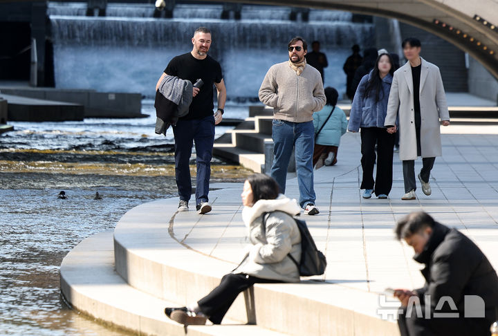 [서울=뉴시스] 김선웅 기자 = 서울 낮 최고기온이 13도를 기록해 포근한 날씨를 보인 27일 오후 서울 청계천 산책로에서 한 외국인 관광객이 반팔 차림으로 산책을 하고 있다. 2025.02.27. mangusta@newsis.com
