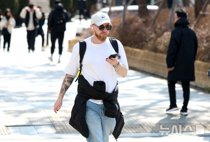 [서울=뉴시스] 김선웅 기자 = 서울 낮 최고기온이 13도를 기록해 포근한 날씨를 보인 27일 오후 서울 종로구 세종대로 사거리에서 한 외국인 관광객이 반팔 차림으로 길을 걷고 있다. 2025.02.27. mangusta@newsis.com