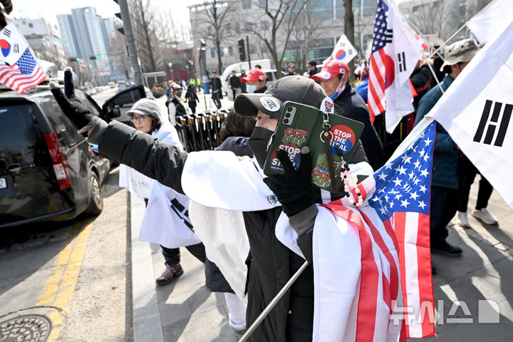[광주=뉴시스] 김혜인 기자 = 광주지역 대학생 등이 '윤석열 대통령 탄핵반대 시국선언'을 개최한 27일 오후 광주 북구 용봉동 전남대학교 후문에서 자유대한민국국민연대 서울 회원들이 태극기를 흔들고 있다. 2025.02.27. hyein0342@newsis.com