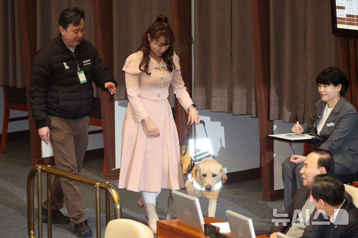 [서울=뉴시스] 권창회 기자 = 김예지 국민의힘 의원과 안내견 태백이가 27일 서울 여의도 국회에서 열린 제422회국회(임시회) 제7차 본회의에서 이동하고 있다. 2025.02.27. kch0523@newsis.com
