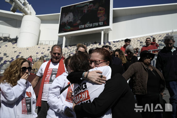 [텔아비브=AP/뉴시스] 28일(현지 시간) 이스라엘 텔아비브의 블룸필드 스타디움에서 하마스에 인질로 잡혔다가 이틀전 시신으로 인도된 차히 이단을 추모하는 공개 추도식이 열려 조문객들이 서로를 위로하며 끌어안고 있다. 2025.02.28