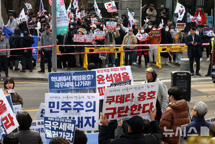[서울=뉴시스] 홍효식 기자 = 28일 오후 서울 동대문구 서울시립대학교 정문 앞에서 윤석열 대통령 파면과 쿠데타 옹호 세력을 규탄하는 긴급 서울시립대 행동 회원들 너머로 자유민주주의를 수호하는 시립대인의 탄핵 반대 시국선언이 진행되고 있다. 2025.02.28. yesphoto@newsis.com