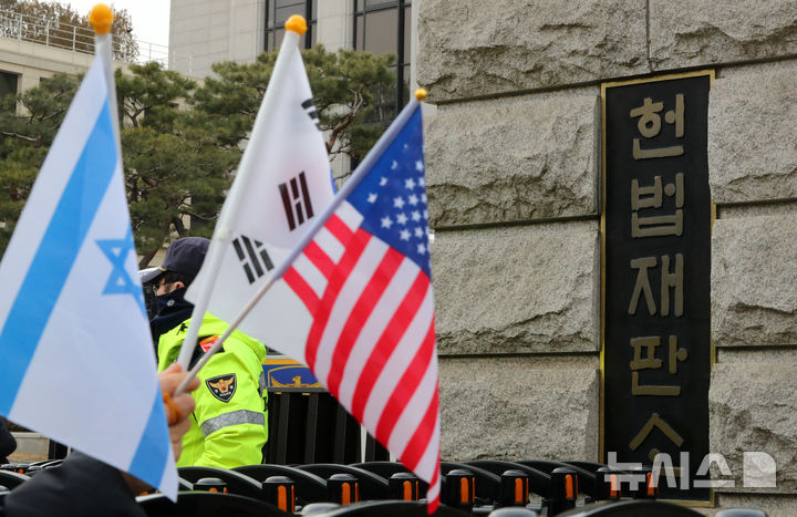 [서울=뉴시스] 김혜진 기자 = 헌법재판소가 헌법재판소가 마은혁 헌법재판관 후보자를 임명하라는 결론을 내렸다. 마 후보자가 임명되면 헌재가 그를 윤석열 대통령 탄핵심판에 참여시킬지 여부가 관심이다. 사진은 28일 서울 종로구 헌법재판소 앞에서 윤석열 대통령 지지자가 국기를 들고 있다. 2025.02.28. jini@newsis.com