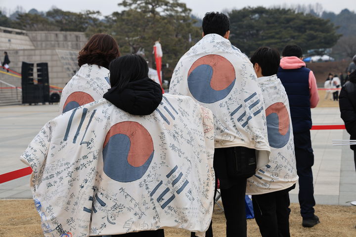 [천안=뉴시스] 박우경 기자=1일 독립기념관 3.1절 문화행사에서 한 가족이 광복군 태극기 담요를 몸에 두르고 있다. spacedust1@newsis.com 2025.3.1 *재판매 및 DB 금지