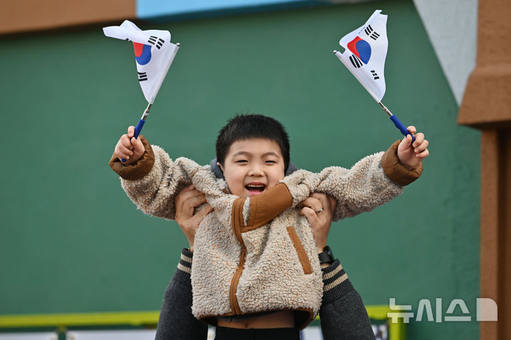 [광주=뉴시스] 이영주 기자 = 제106주년 3·1절을 맞은 1일 오전 광주 광산구 고려인마을에서 한 어린 아이가 아버지의 손에 들린 채 태극기를 흔들고 있다. 2025.03.01. leeyj2578@newsis.com