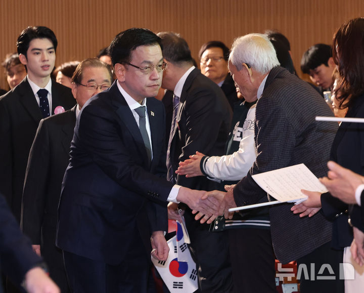[서울=뉴시스] 조수정 기자 = 최상목 대통령 권한대행 부총리 겸 기획재정부 장관이 1일 서울 중구 숭의여자대학교에서 열린 제106주년 3·1절 기념식에 입장하며 독립유공자 후손과 인사나누고 있다. 왼쪽 뒤는 피겨스케이트 국가대표 차준환, 왼쪽 두번째는 이종찬 광복회장. 2025.03.01. chocrystal@newsis.com