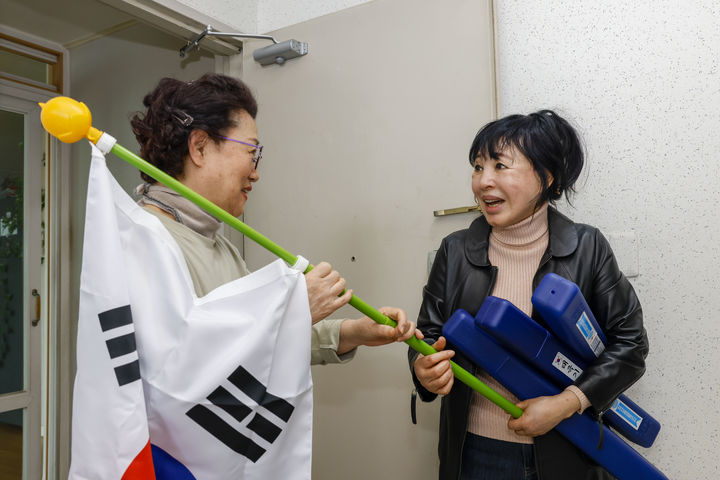 [칠곡=뉴시스] 김금숙(오른쪽) 이장이 주민에게 태극기를 나눠주고 있다 (사진=칠곡군 제공) 2025.03.02 photo@newsis.com *재판매 및 DB 금지