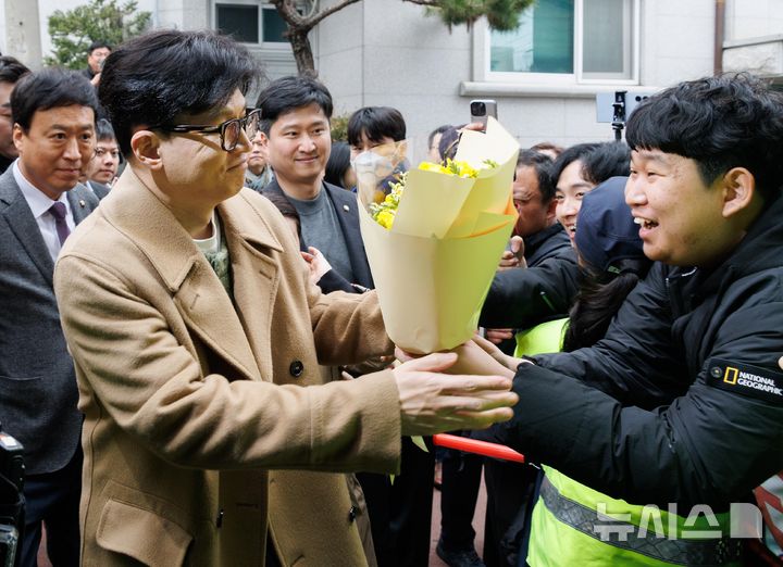 [서울=뉴시스] 정병혁 기자 = 한동훈 국민의힘 전 대표가 2일 오후 서울 종로구 나온 씨어터에서 제2연평해전을 다룬 공연 '바다는 비에 젖지 않는다'를 관람하기 위해 이동하며 지지자에게 꽃다발을 전달받고 있다. (공동취재) 2025.03.02. photo@newsis.com