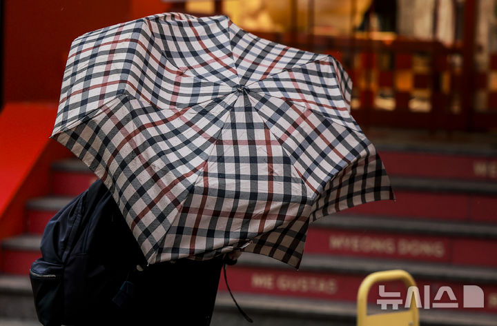 [서울=뉴시스] 정병혁 기자 = 2일 서울 중구 명동거리에서 시민들이 쓴 우산이 바람에 날리고 있다. 2025.03.02. jhope@newsis.com