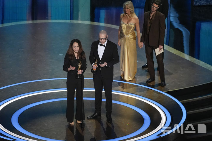 [로스앤젤레스= AP/뉴시스] 3월 2일 개막한 돌비극장의 오스카상 시상식에서 "사이프러스 그늘 아래서"란 에니메이션으로 수상한 이란의 시린 소하니(왼쪽)와 호세인 몰라예미가 관중에게 인사하고 있다.&nbsp; 바로 뒤 여배우는 골디 혼. 2025. 03. 03. 