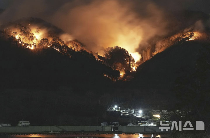 [오후나토=AP/뉴시스]지난해 일본 북부 이와테현 오후나토에서 산불이 주택 뒤쪽으로 번지고 있다. 일본 이와테현 오쓰치초(大槌町) 일대 2곳에서 산불이 발생해 이틀째 진화 작업을 이어가고 있다. *사진과 본문은 관계 없음. 2026.04.23.