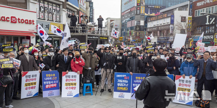 [전주=뉴시스] 강경호 기자 = 개강을 하루 앞둔 3일 전북 전주시 전북대학교 구정문 앞 버스킹존에서 열린 윤석열 대통령의 탄핵을 반대하는 대학생 시국선언 집회에서 대표 발언자인 이사야씨가 구호를 외치자 집회에 참석한 이들이 구호를 제창하고 있다. 2025.03.03. lukekang@newsis.com