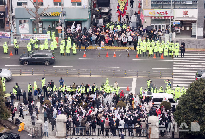 [부산=뉴시스] 하경민 기자 = 동아대 재학생으로 구성된 '자유민주수호를 위한 동아인들'과 시민 등이(사진 아래) 3일 오후 부산 서구 동아대학교 부민캠퍼스 정문 앞에서 윤 대통령 탄핵 반대 시국선언을 열고 있는 가운데 도로를 사이에 두고 윤석열 조속한 파면을 촉구하는 동아대 재학생, 졸업생, 민주시민 등이(위) 윤 대통령 탄핵을 촉구하는 구호를 외치고 있다. 2025.03.03. yulnetphoto@newsis.com