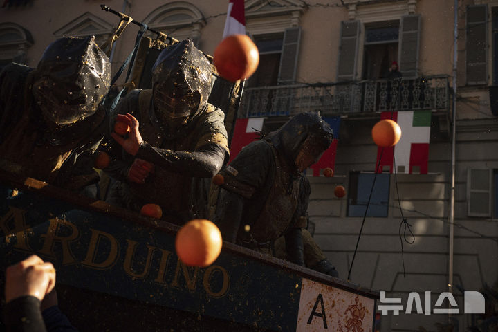 [이브레아=AP/뉴시스] 3일(현지 시간) 이탈리아 북부 피에몬테주 이브레아에서 카니발의 일환으로 '오렌지 전투'가 열려 중세 병사와 평민으로 역할을 나눈 사람들이 '오렌지 전투'를 벌이고 있다. 12세기 봉건시대에 비올레타라는 평민 여성이 자신에게 '초야권'을 행사하려던 영주의 목을 베면서 민중 봉기를 촉발한 것이 '오렌지 전투'의 기원으로 알려져 있다. 축제에 사용되는 오렌지는 식용에 부적합한 것들로 후에 퇴비로 이용된다. 2025.03.04.