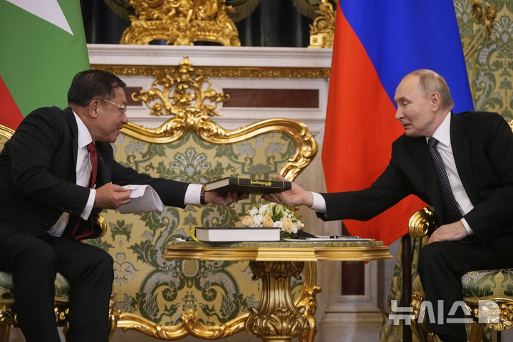 [모스크바=AP/뉴시스]4일(현지 시간) 러시아를 방문한 미얀마 군사정권 수장 민 아웅 흘라잉 최고사령관이 블라디미르 푸틴 대통령과 회담에서 미얀마와 러시아의 관계를 설명한 1838년 불교 서적을 선물하고 있다. 2025.03.05.