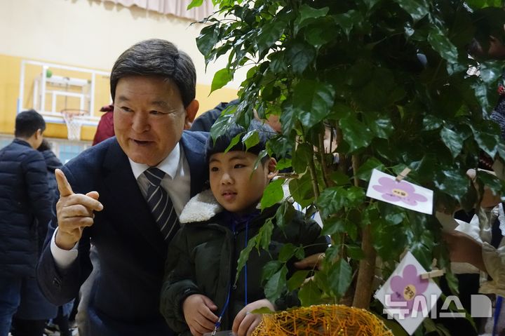 [제주=뉴시스] 양영전 기자 = 김광수 제주교육감과 제주남초등학교 입학생이 4일 오전 학교 강당에서 열린 2025학년도 입학식에서 희망 나무 쪽지를 부착하고 기념 촬영을 하고 있다. 2025.03.04. 0jeoni@newsis.com 