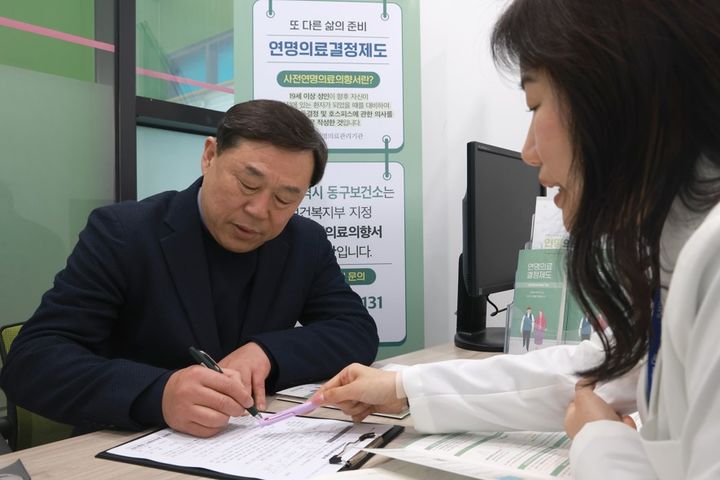 [울산=뉴시스] 박수지 기자 = 김종훈 울산 동구청장이 4일 사전연명의료의향서 등록기관으로 지정받은 동구보건소를 방문해 사전연명의료의향서를 작성하고 1호 등록자로 기념촬영을 하고 있다. (사진=동구 제공) 2025.03.04. photo@newsis.com *재판매 및 DB 금지