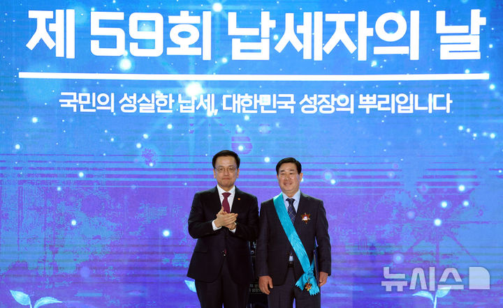 [서울=뉴시스] 조수정 기자 = 최상목 대통령 권한대행 부총리 겸 기획재정부 장관이 4일 서울 중구 동대문디자인플라자에서 열린 제59회 납세자의 날 기념식에서 이용호 정현프랜트 대표이사에게 금탑 산업훈장을 수여한 뒤 기념촬영을 하고 있다. 2025.03.04. chocrystal@newsis.com