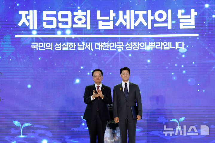 [서울=뉴시스] 조수정 기자 = 최상목 대통령 권한대행 부총리 겸 기획재정부 장관이 4일 서울 중구 동대문디자인플라자에서 열린 제59회 납세자의 날 기념식에서 배우 지진희에게 대통령 표창을 수여 후 기념촬영하고 있다. 2025.03.04. chocrystal@newsis.com