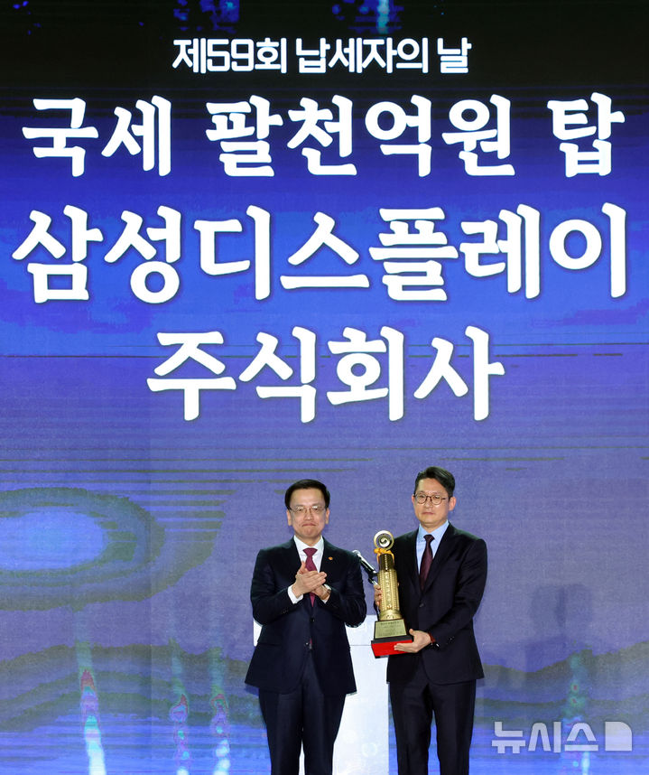 [서울=뉴시스] 조수정 기자 = 최상목 대통령 권한대행 부총리 겸 기획재정부 장관이 4일 서울 중구 동대문디자인플라자에서 열린 제59회 납세자의 날 기념식에서 삼성디스플레이 임영재 재경팀장에게 고액납세탑 팔천억원탑을 전달한 후 기념촬영하고 있다. 2025.03.04. chocrystal@newsis.com