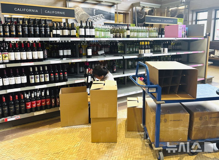 [토론토=AP/뉴시스] 4일(현지 시간) 캐나다 온타리오주 토론토의 주류 판매장 LCBO에서 이곳 직원이 미국 제품을 상자에 담고 있다. 캐나다와 멕시코가 미국이 부과한 관세에 대응해 보복 관세 방침을 밝힌 가운데 도널드 트럼프 미국 대통령은 이에 추가 관세를 부과하겠다고 밝혔다. 2025.03.05.