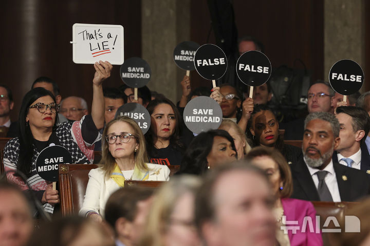 [워싱턴=AP/뉴시스] 도널드 트럼프 미국 대통령이 4일(현지 시간) 워싱턴 의회에서 상·하원 합동 연설을 하는 동안 민주당 의원들이 이에 반대하는 팻말을 들고 있다. 2025.03.05.