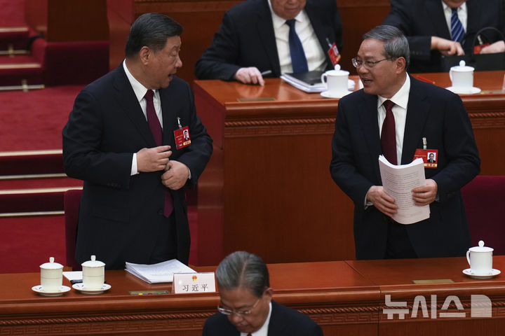 [베이징=AP/뉴시스] ﻿﻿올해 정부 업무 1순위로 내수진작을 제시한 중국 정부가 소득 증대와 소비 환경 개선 등이 포함된 종합 대책을 발표했다. 사진은 시진핑(왼쪽) 중국 국가주석과 리창 총리가 5일 중국 베이징 인민대회당에서 열린 전국인민대표대회 개막식에서 대화를 나누는 모습. 2025.03.17