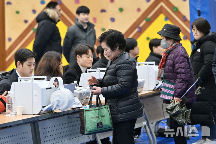 [광주=뉴시스] 이영주 기자 = 제1회 전국 동시 새마을금고 이사장 선거가 치러지는 5일 오전 광주 서구 양동초등학교에서 유권자들이 투표지를 받기 위해 신분증을 제시하고 있다. 2025.03.05. leeyj2578@newsis.com