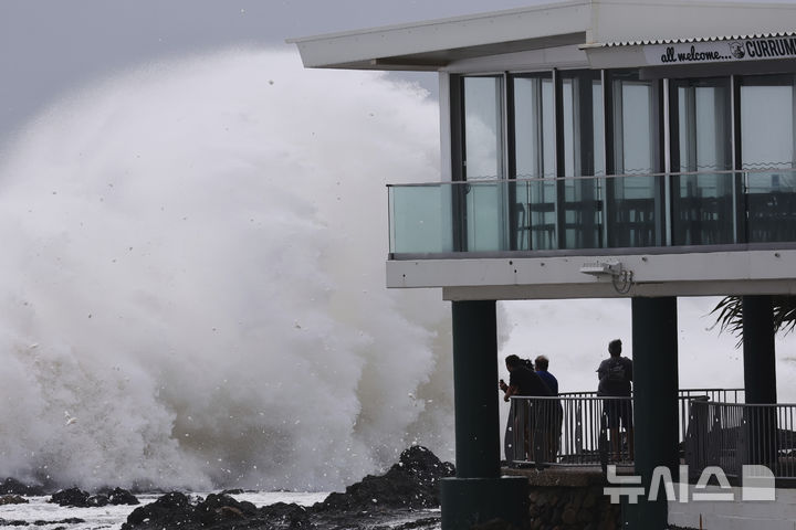 [골드코스트=AP/뉴시스] 6일(현지 시간) 호주 퀸즐랜드주 골드코스트에서 사람들이 사이클론 알프레드로 인한 거대한 파도가 해안을 강타하는 모습을 지켜보고 있다. 2025.03.06.