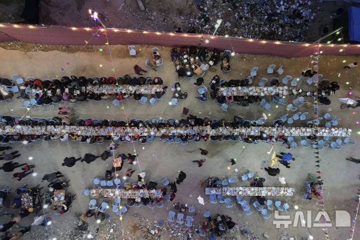 [가자시티=AP/뉴시스] 6일(현지 시간) 가자지구 가자시티에서 팔레스타인 주민들이 파괴된 집과 건물 잔해로 둘러싸인 대형 식탁에 모여 라마단 금식 종료 후 이프타르를 함께하고 있다. 2025.03.07.
