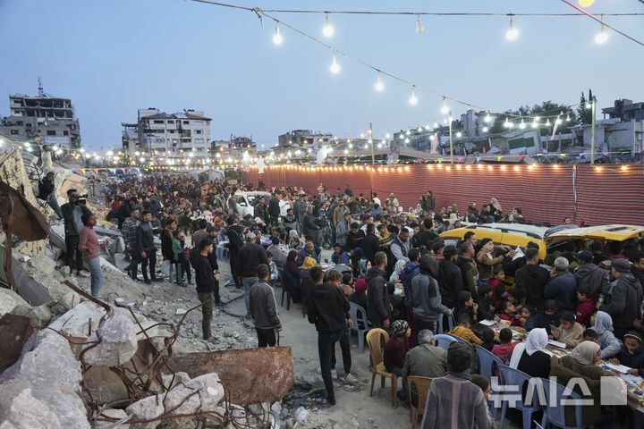 [가자시티=AP/뉴시스] 6일(현지 시간) 가자지구 가자시티에서 팔레스타인 주민들이 파괴된 집과 건물 잔해로 둘러싸인 대형 식탁에 모여 라마단 금식 종료 후 이프타르를 함께하고 있다. 2025.03.07.
