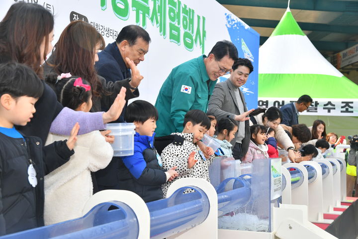 [울산=뉴시스] 7일 울산 울주군 태화강생태관 인근 태화강 선바위교 일대에서이순걸 울주군수와 관계 공무원, 인근 어린이집 원아들이 참석한 가운데 어린 연어 방류행사가 진행되고 있다. (사진=울산 울주군 제공) 2025.03.07. photo@newsis.com *재판매 및 DB 금지