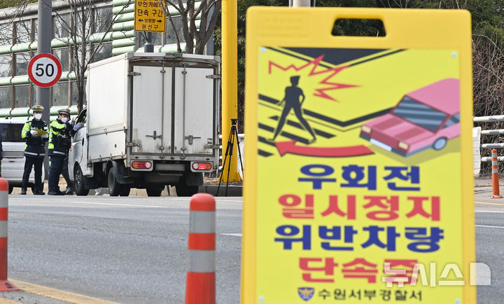 [수원=뉴시스] 횡단보도를 잠시 벗어난 상태에서 길을 건너던 사람을 쳤다는 이유로 '보행자가 아니다'라고 판단해 운전자를 불기소 처분한 것은 부당하다는 헌법재판소 판단이 나왔다. 경찰이 지난해 3월 7일 경기도 수원시 세류동 한 사거리에서 우회전 시 일시정지 의무 위반 차량 단속을 하고 있다. (사진=뉴시스DB). 2026.05.26. photo@newsis.com