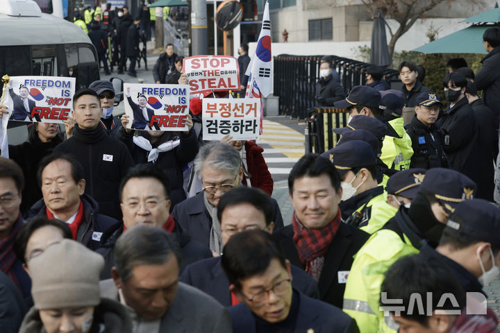 [서울=뉴시스] 최동준 기자 = 법원이 윤석열 대통령의 구속취소 청구를 인용한 7일 서울 용산구 한남동 대통령 관저 앞에서 국민의힘 탄핵반대 당협위원장 모임 관계자들이 윤 대통령 석방을 환영 입장문을 발표하는 뒤로 지지자들이 손팻말을 흔들고 있다. 2025.03.07. photocdj@newsis.com