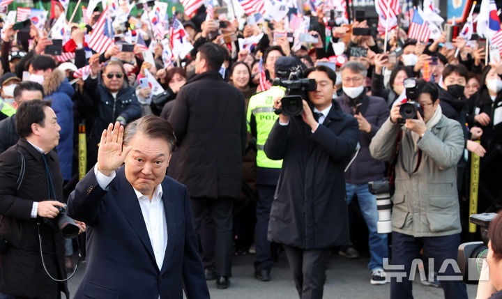 [서울=뉴시스] 김금보 기자 = 석방된 윤석열 대통령이 8일 오후 서울 용산구 한남동 관저 입구에서 지지자들에게 인사하고 있다. 2025.03.08. kgb@newsis.com