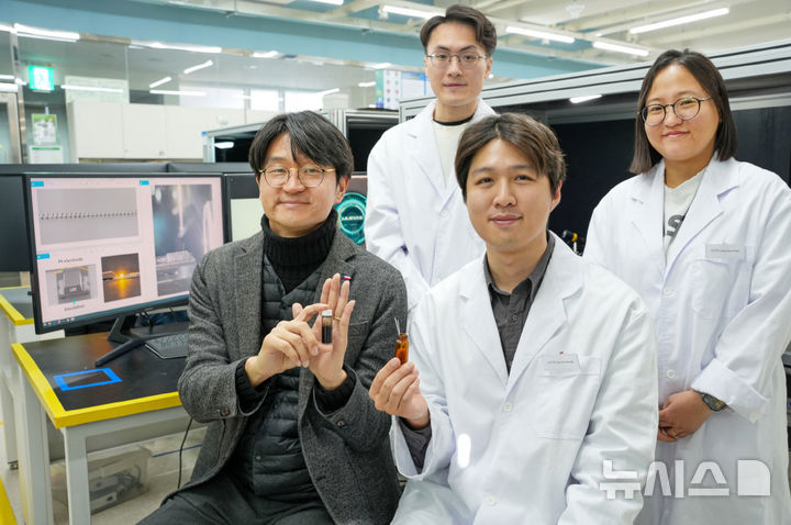[창원=뉴시스]한국전기연구원(KERI) 스마트3D프린팅연구팀 설승권(앞줄 왼쪽) 박사팀이 맥신을 이용한 3D 프린팅용 잉크와 노즐을 들고 포즈를 취하고 있다.(사진=KERI 제공) 2025.03.10.photo@newsis.com