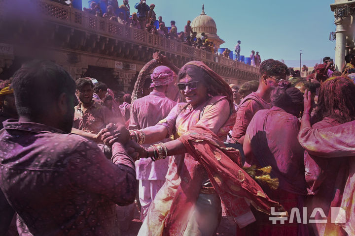 [난드가온=AP/뉴시스] 9일(현지 시간) 인도 뉴델리 남쪽 115㎞ 떨어진 난드가온 마을의 난드그람 사원에서 라트마르 홀리 축제가 열려 주민들이 색가루를 뿌리며 축제를 즐기고 있다. 2025.03.10.