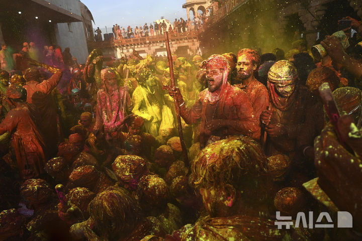 [난드가온=AP/뉴시스] 9일(현지 시간) 인도 뉴델리 남쪽 115㎞ 떨어진 난드가온 마을의 난드그람 사원에서 라트마르 홀리 축제가 열려 주민들이 색가루를 뿌리며 축제를 즐기고 있다. 2025.03.10.