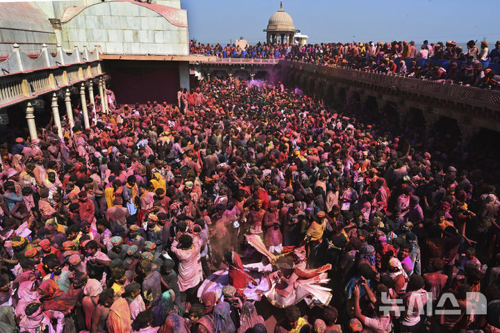 [난드가온=AP/뉴시스] 9일(현지 시간) 인도 뉴델리 남쪽 115㎞ 떨어진 난드가온 마을의 난드그람 사원에서 라트마르 홀리 축제가 열려 각종 색가루를 뒤집어쓴 주민들이 축제를 즐기고 있다. 2025.03.10.