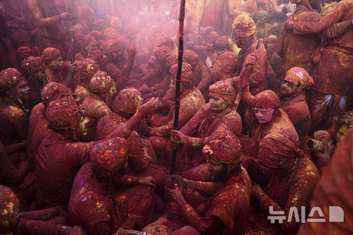 [난드가온=AP/뉴시스] 9일(현지 시간) 인도 뉴델리 남쪽 115㎞ 떨어진 난드가온 마을의 난드그람 사원에서 라트마르 홀리 축제가 열려 주민들이 서로에게 색가루를 뿌리며 축제를 즐기고 있다. 2025.03.10.