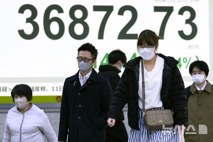 [도쿄=AP/뉴시스]지난 10일 일본 도쿄의 한 증권사 전광판 앞을 시민들이 걸어가고 있다. 2025.03.11.