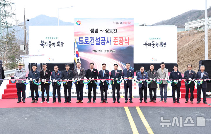 [창원=뉴시스]10일 오후 경남 김해시 상동면 대감터널 부근에서 열린 국지도 60호선 생림~상동 구간 준공식에 참석한 박완수 도지사 등이 준공 기념 테이프를 자르고 있다.(사진=경남도 제공) 2025.03.10. photo@newsis.com