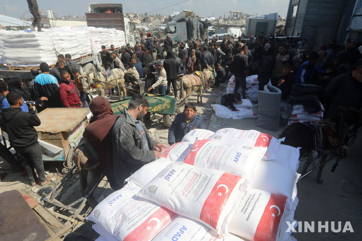 [자발리아=신화/뉴시스] 지난 10일(현지 시간) 가자지구 북부 자발리아 난민촌에 있는 유엔팔레스타인난민구호기구(UNRWA) 배급소에서 팔레스타인 주민들이 인도적 지원으로 밀가루를 받고 있다. 2025.03.15.